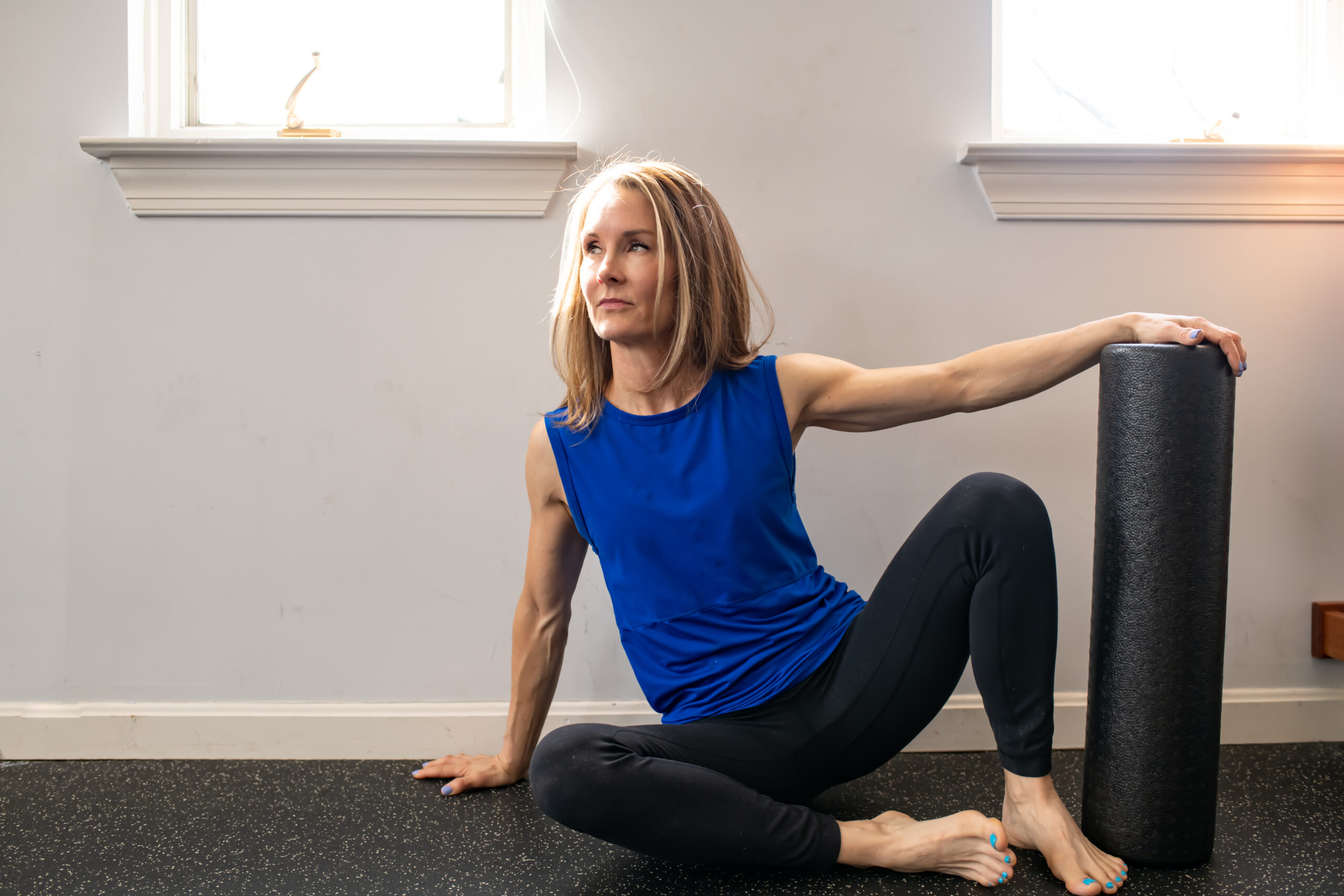 Adrien on a workout mat with a foam roller