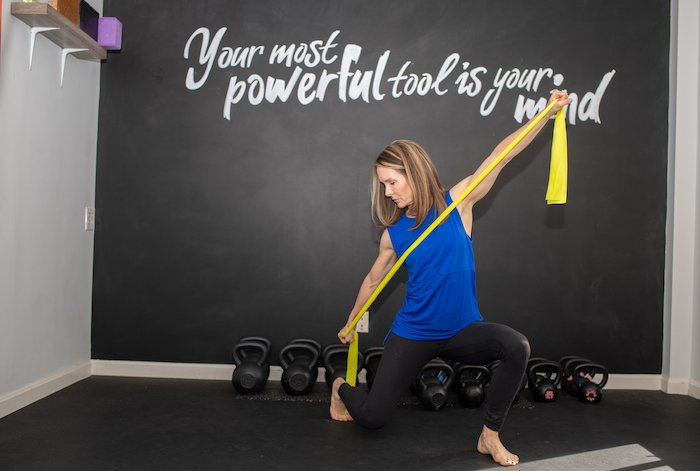 Adrien Cotton Of Alexandria Wellness Using A Yellow Theraband To Stretch Right