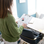 Adrien Cotton Looking At Her Wellness Wheel In Her Office