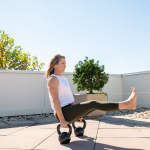 Adrien Cotton Balances In A Pike Position With Legs Extended On Two Kettlebells.
