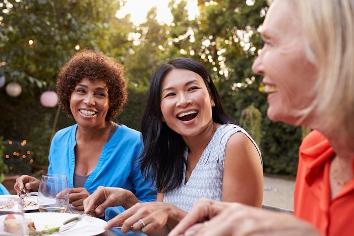 Mature Female Friends Enjoying A Meal Outdoors