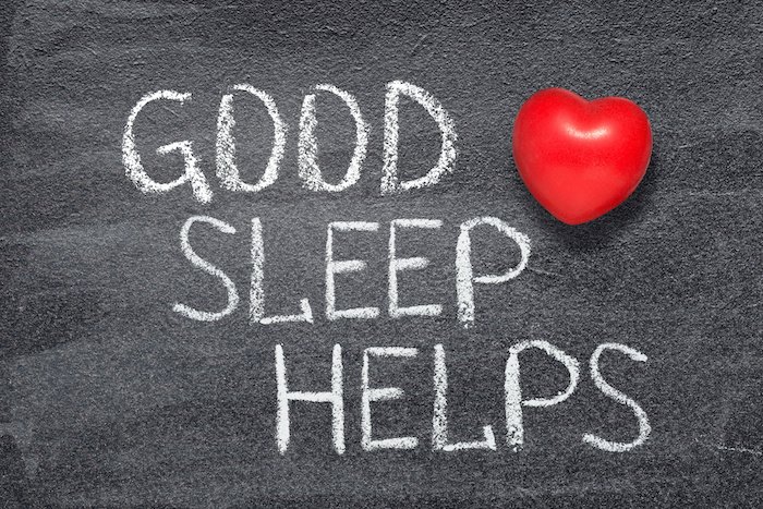 Good sleep helps written on a black board with a heart