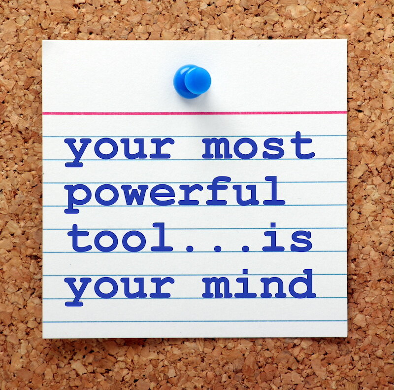 Note Posted On A Cork Board With A Blue Tack That Reads &Quot;Your Most Powerful Tool...is Your Mind&Quot; In Blue On White.