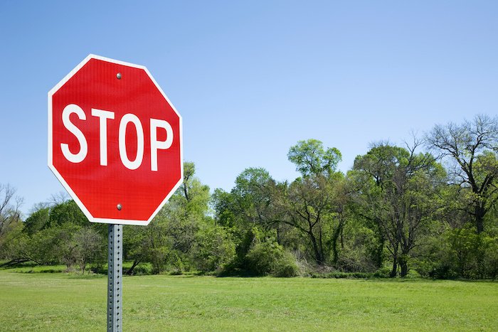 Stop Sign With Green Field Behind It