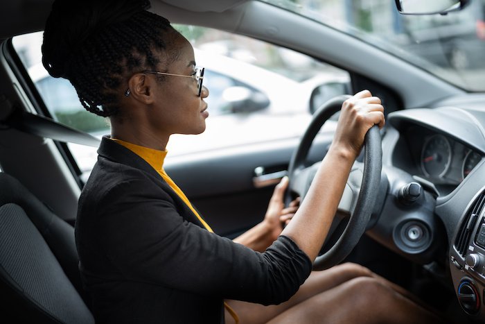 Young Black Woman Holding The Steering Wheel While Driving A Car.