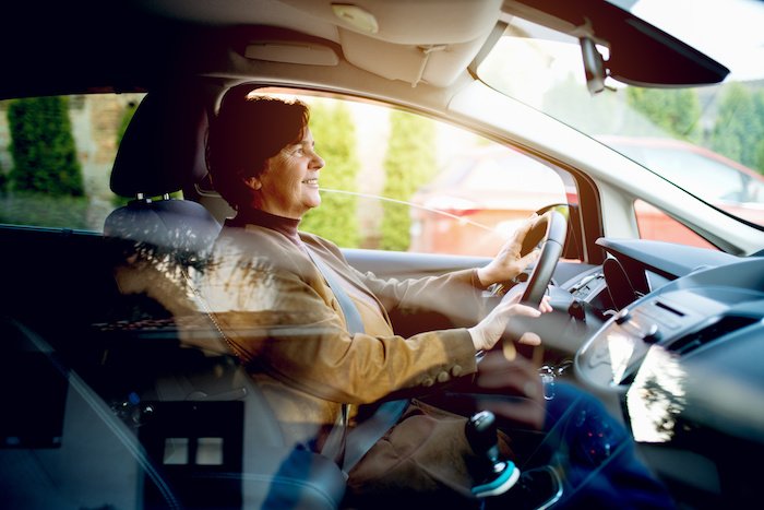 Woman Driving A Car And Smiling