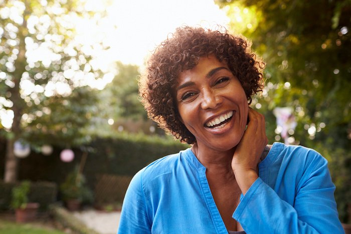 Mature Woman Smiling In A Backyard Garden