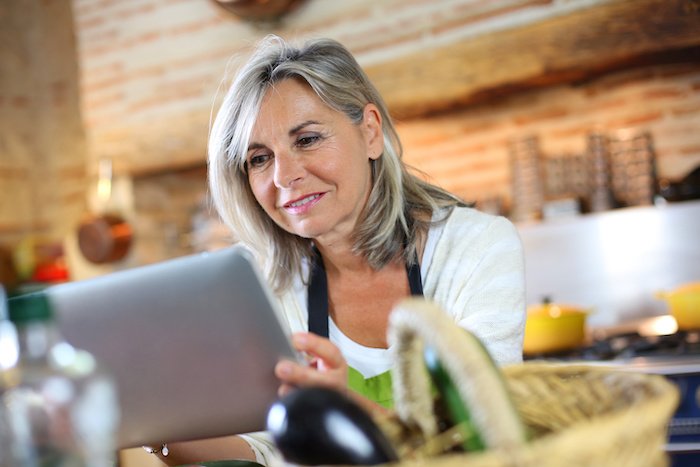 Mature Woman Looking At A Recipe On A Tablet