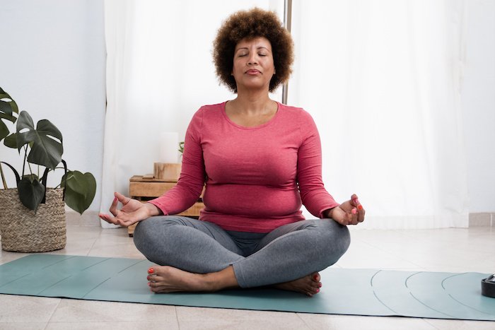 Mature Black Woman Sits And Meditates