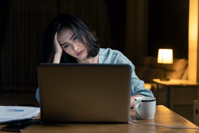 Business Woman Holding Her Head While Looking At Ta Laptop At Night