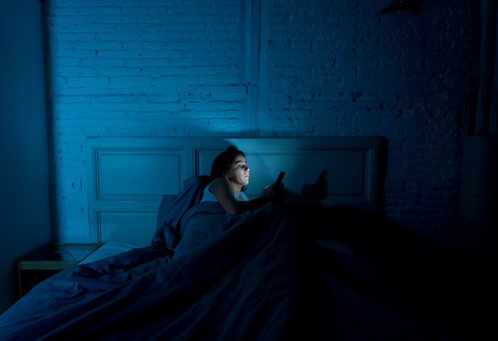 Woman On Phone In Bed Late At Night.