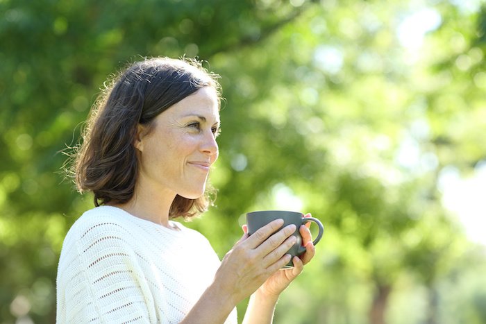 Satisfied Adult Woman Holding A Coffee Cup Outside