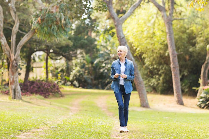 Relaxed Older Woman Walking In A Park