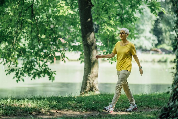 Mature Woman Enjoying A Walk By A Lake