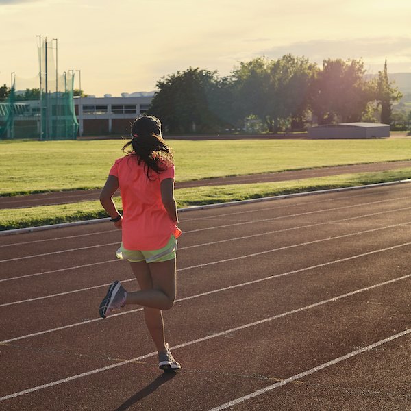 Girl Running Backwards On A Track Towards Sunset